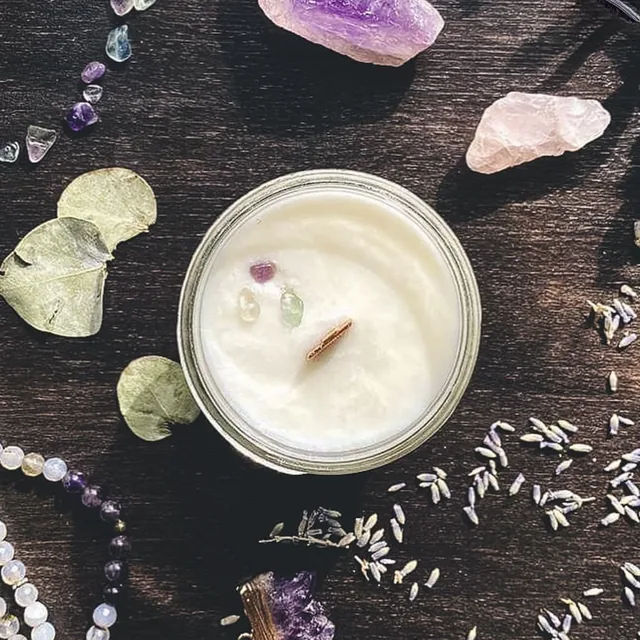 Chandelle en cire de soya vue de haut, entourée d’améthyste, de quartz rose, d’eucalyptus et de lavande.