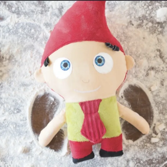 Peluche lutin des TrOnches couchée dans la farine, entourée de guimauves.